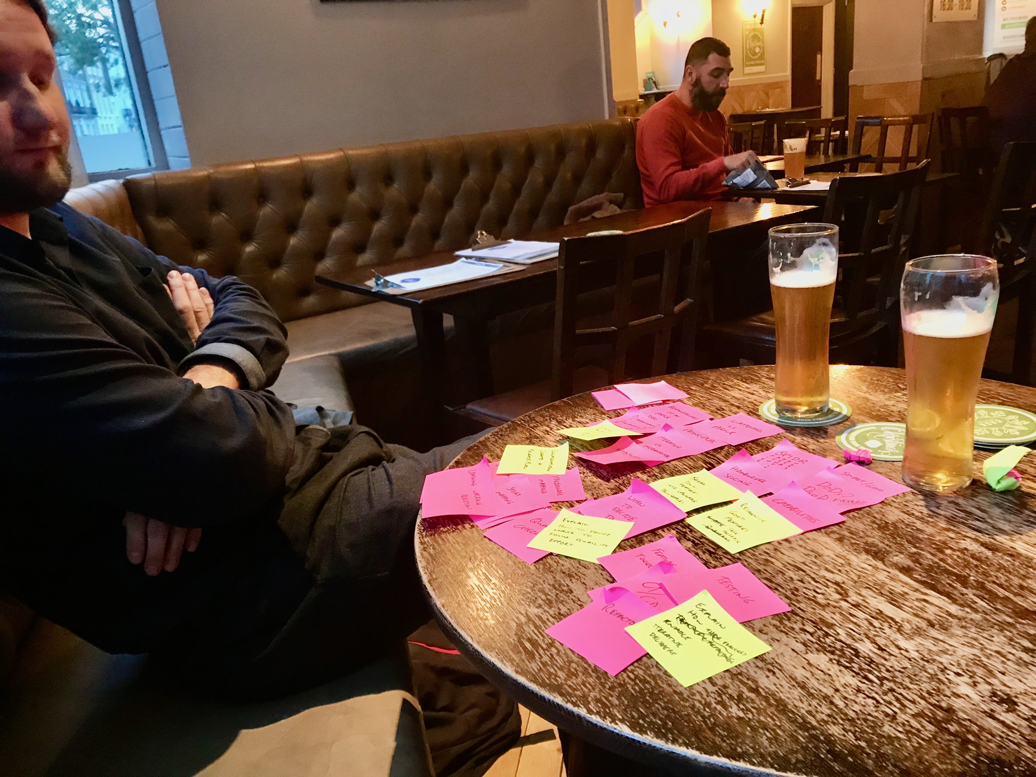 Jakub with a table full of stickies and a pint